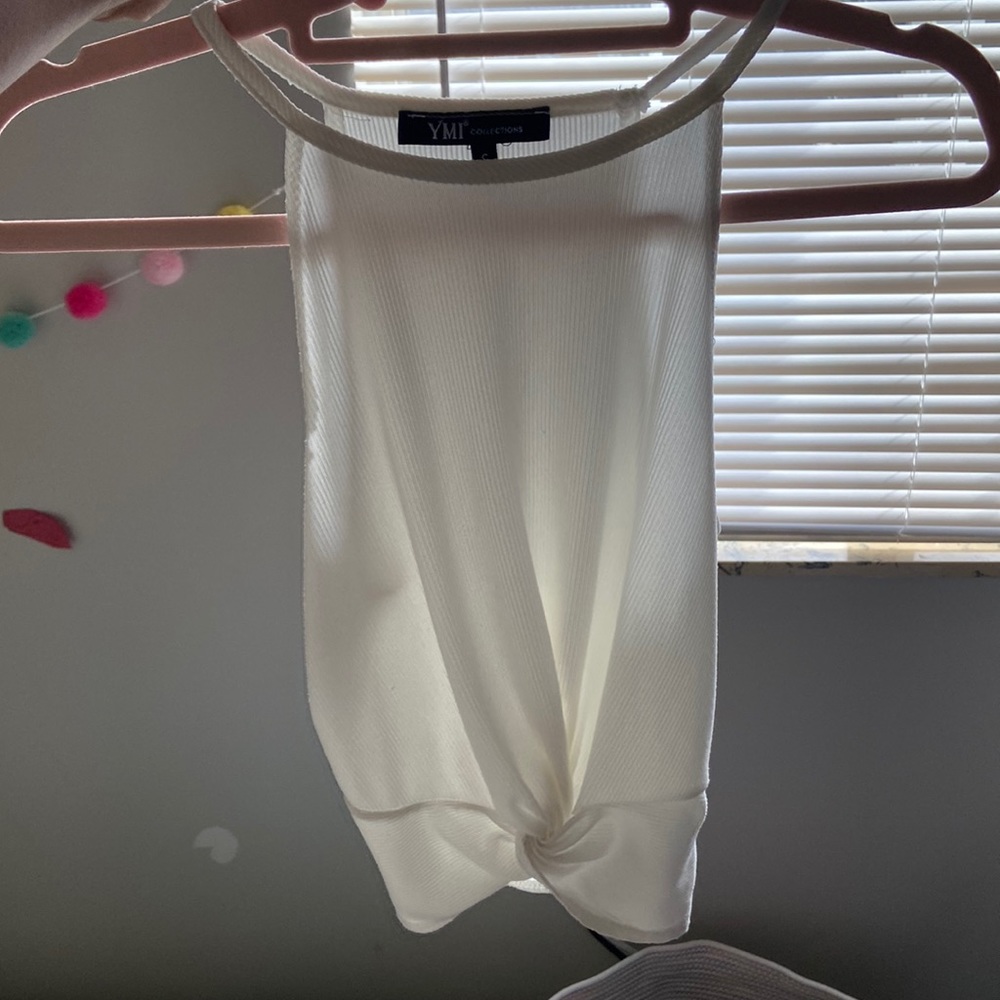 White/crème colored tank top with a small knot at the bottom.